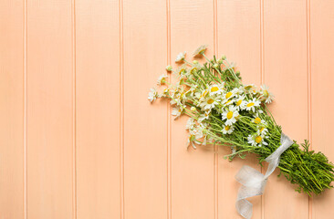 Fototapeta na wymiar Bouquet of beautiful chamomile flowers on color wooden background