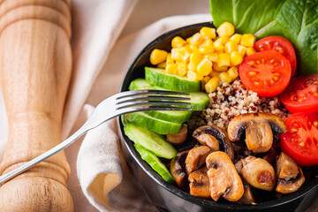 bowl of healthy quinoa with vegetables on a dark rustic background