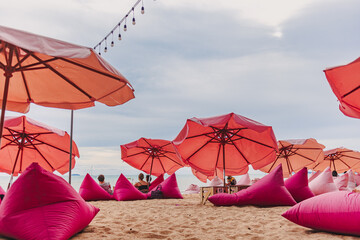 Pink umbrella beach cafe with bright sky in summer.