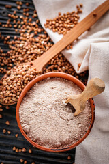 fresh natural buckwheat flour on a dark wooden rustic background culinary concept