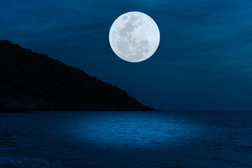 Fototapeta na wymiar Full moon on sky over sea at night.