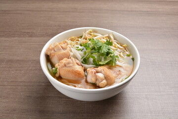 cook clear hot soup with chicken meat, vegetable  and noodle on wood background asian halal menu
