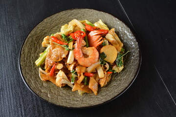 stir fried noodle kway teow with seafood phad Thai on wood background asian halal menu
