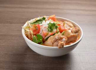 cook curry spicy chilli laksa soup with chicken meat, vegetable  and noodle on wood background asian halal menu