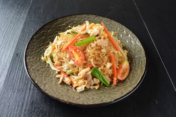 stir fried noodle vermicelli with seafood phad Thai on wood background asian halal menu