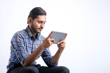 Young indian man using tablet over white background.