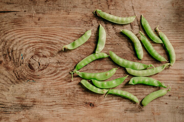 young peas on a wooden background. the view from the top