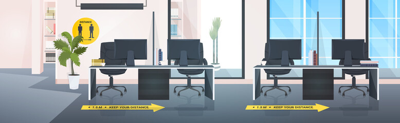 workplace desks with signs for social distancing yellow stickers coronavirus epidemic protection measures