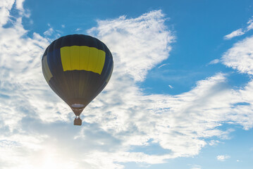 Hot Air Balloon and blue sky white cloud.Blue yellow hot air balloon in the air at summer evening.