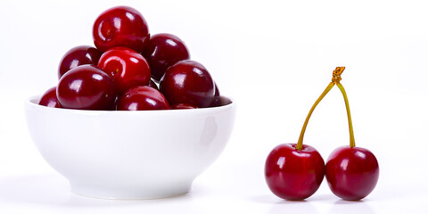 Cherry berries in a white cup on a white background. Isolated. Ripe cherries. Red delicious cherry.