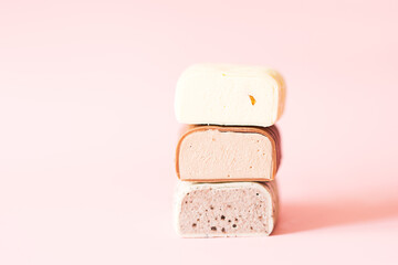 Different chocolate Popsicles cut with filling lying on top of each other. Pink background