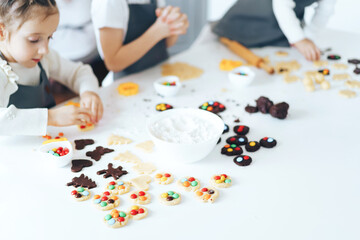 Children prepare cookies with sweets, a boy rolls out the dough with a rolling pin. Leisure activity with children concept