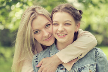 happy mother with her daughter hugging a teenager in the summer. Caring happy mother enjoy day with teenage girl child, laugh have fun. Mother giving her daughter advice.