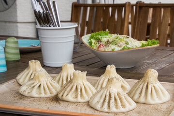 Georgian traditional food khinkali on the plate in restaurant, ready to eat, hot dish.