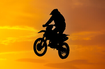 Fototapeta na wymiar Silhouette of a man on a motorcycle against the background of a golden