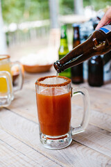 Michelada mexican beer with tomato juice, hot sauce and lemon, Mexican cocktail drink in Mexico
