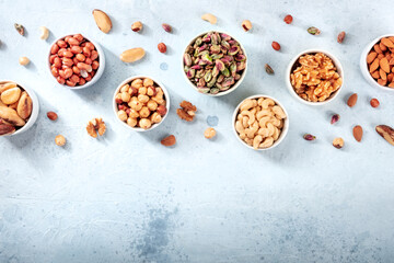 Nuts variety, top shot with a place for text. Cashews, almonds, pistachios and many other nuts, in bowls and scattered