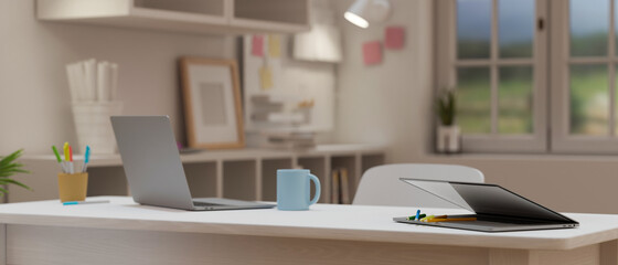 Cropped shot of portable workspace with laptop on light wooden table in cozy office room