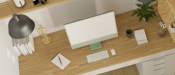 Top view of modern working space designed with computer monitor mock-up and decorations on the wooden table