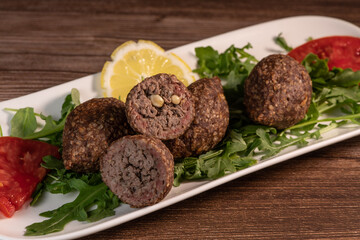 Traditional kebbe and pita bread on big round plate in lebanese restaurant. High quality photo