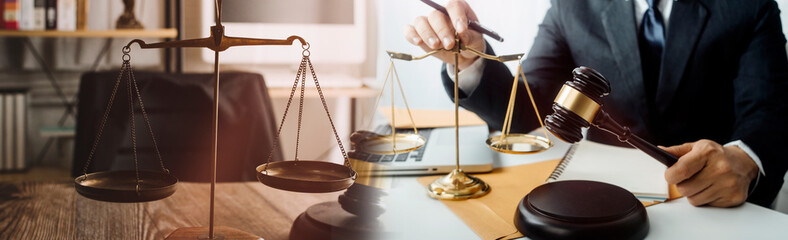 Justice and law concept.Male judge in a courtroom with the gavel, working with, computer and...