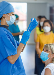 young doctor wears face mask rubber gloves and blue hospital uniform using needle syringe sucking...