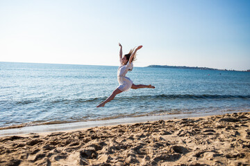 Fototapeta na wymiar woman running on the beach, dancing and jumping on the beach
