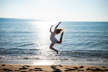 woman running on the beach, dancing and jumping on the beach