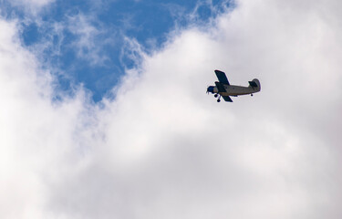 An old biplane flies overhead. Side view. Aerial concept.