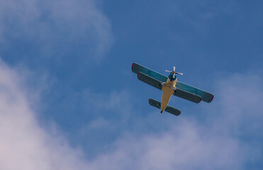 Old biplane in the sky in the clouds. Bottom view. Aerial concept.