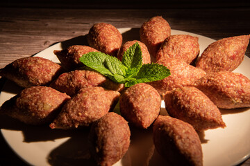 Traditional kebbe and pita bread on big round plate in lebanese restaurant. High quality photo