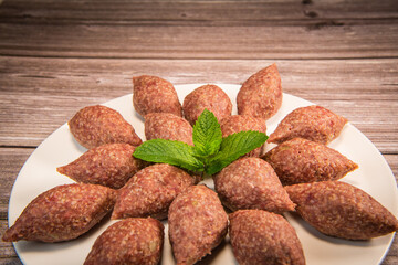 Traditional kebbe and pita bread on big round plate in lebanese restaurant. High quality photo