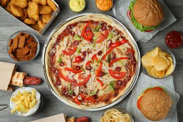 Different fast food on gray textured table