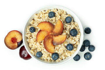Bowl of oatmeal with tasty ingredients isolated on white background