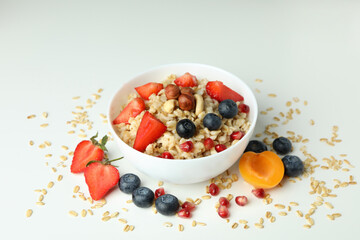 Bowl of oatmeal and ingredients on white background