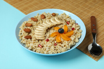 Concept of tasty eating with oatmeal on blue background