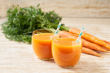 Fresh carrot smoothies and vegetables on a wooden table,close-up.