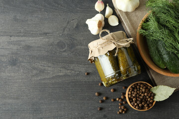 Fresh pickles and ingredients on dark wooden table