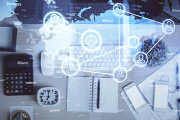 Social network hologram drawings over computer on the desktop background. Top view. Multi exposure. Concept of people connection.