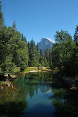 Fototapeta na wymiar Merced River passing through the Yosemite Valley in the background is half dome mountain in Yosemite National Park, California, United States