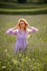 Fototapeta premium Portrait of smiling blonde woman on the lavender field
