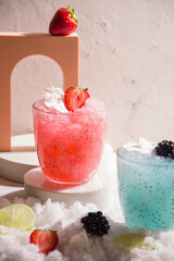 Drink with ice and strawberries on a gray background.