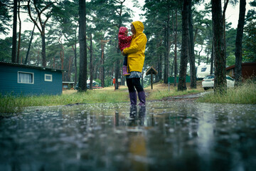 Unwetter - Nach heftigen Regen stehen Frau und Kind im Wasser - obrazy, fototapety, plakaty