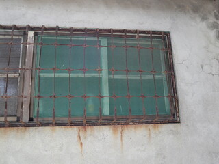 vintage window with rusty bars on the aged wall design for ancient concept