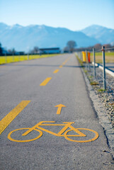 Obraz premium Cycling Lane on the Side of a Road with Mountain in a Sunny Day in Locarno, Ticino in Switzerland.