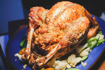 Whole baked golden crispy chicken in a pan cooked with potatoes