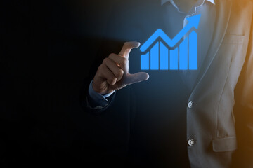 Businessman man holding a graph with positive profits growth. plan graph growth and increase of chart positive indicators in his business.more profitable and growing.