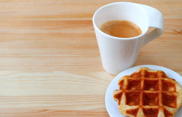 Plate of a Liege Waffle with Blurry Hot Coffee in Background