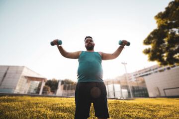 
a fat young man doing weights outdoors.
willpower.