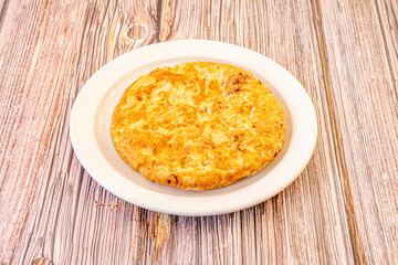Spanish omelette for one person cooked well curdled on white plate